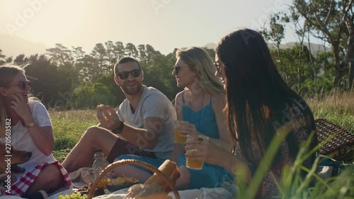 Beautiful friends having fun at picnic sunset photo