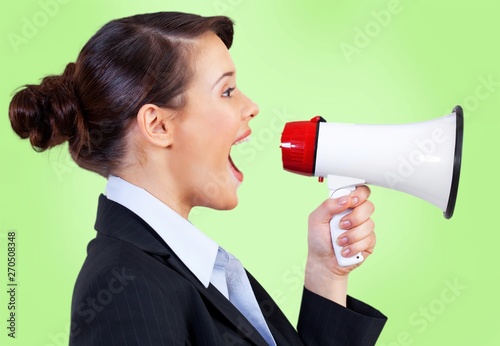 Beautiful woman shouting into megaphone and pointig with finger photo