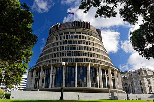 The Beehive, New Zealand's parliament building with the New Zealand flag flying against a blue sky