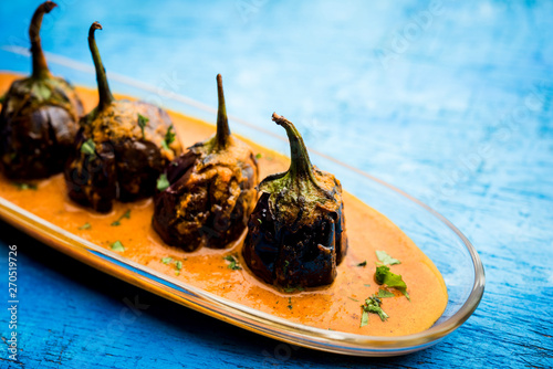 Baingan masala / Eggplant / brinjal curry served in bowl or pan, selective focus photo