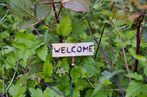 Welcome message outside the door. Cute little banner sign in garden outside.