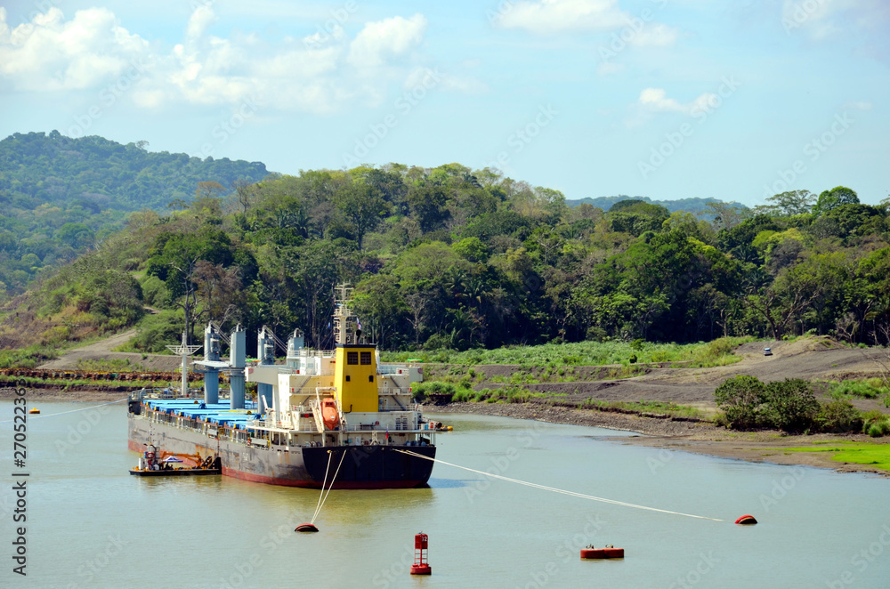 Landscape of the Panama Canal, cargo ship moored to the canal bank. 