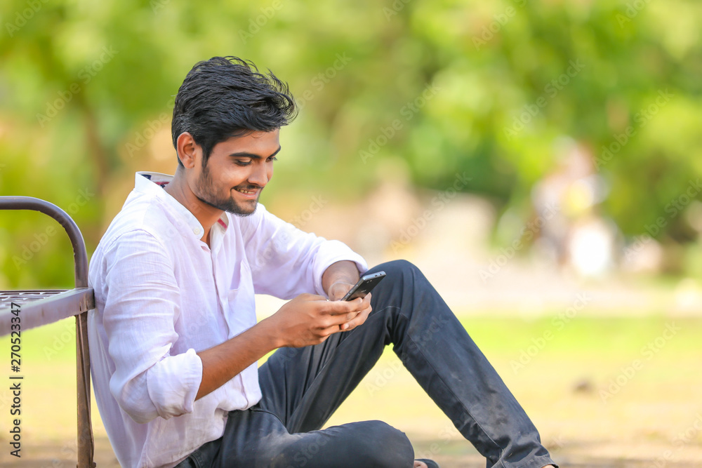 Young indian Collage student using mobile Young indian Collage student using mobile