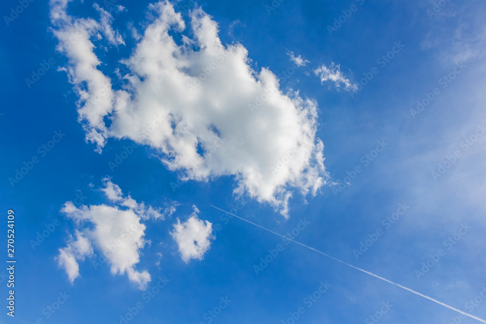 Trails from an airplane in the sky flying between the clouds_ Trails from an airplane in the sky flying between the clouds_
