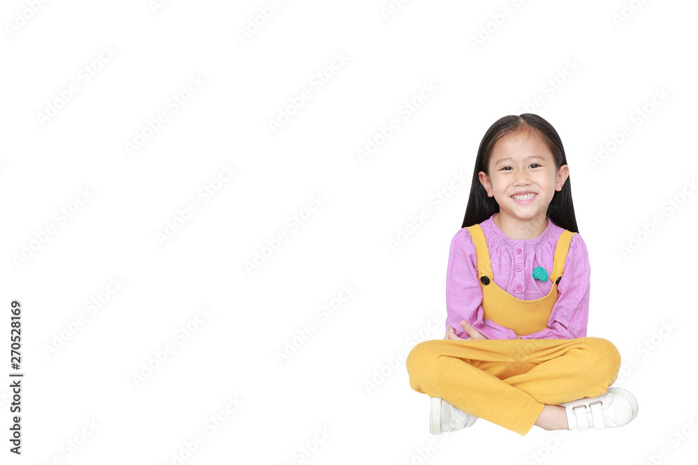 Portrait of happy little Asian child girl in pink-yellow pink-yellow dungarees sitting isolated over white background with copy space. Portrait of happy little Asian child girl in pink-yellow pink-yellow dungarees sitting isolated over white background with copy space.