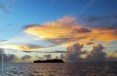 Magical play of clouds in the skies at sunset reflected in the waters of Saipan lagoon, with Managaha Island in view photo