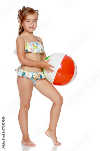 Little girl in a swimsuit with a ball