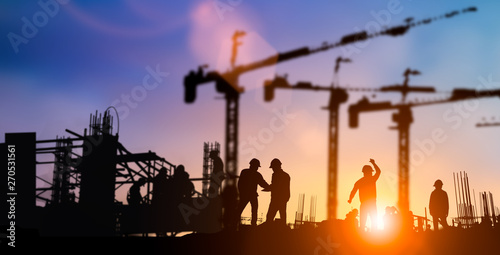 Silhouette of engineer and construction team working at site over blurred background for industry background with Light fair.Create from multiple reference images together