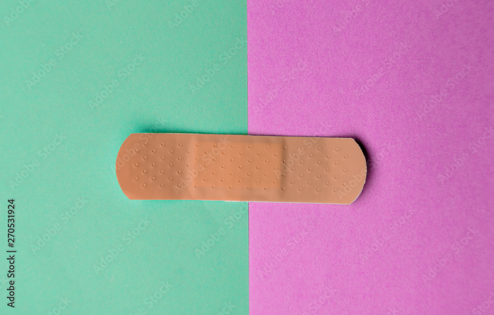 Adhesive bandage or Sticking plaster on a two colored paper background. Adhesive bandage or Sticking plaster on a two colored paper background.