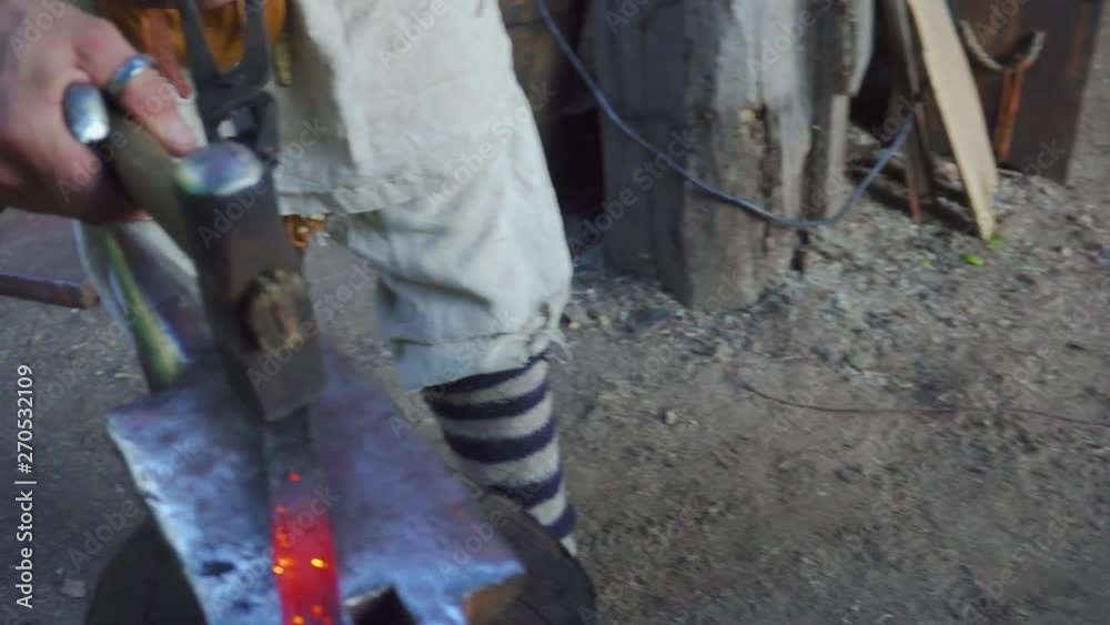 Blacksmith working with blacksmith furs in forge. Hot metal part in fire, then on stithy. Blacksmith working with blacksmith furs in forge. Hot metal part in fire, then on stithy.