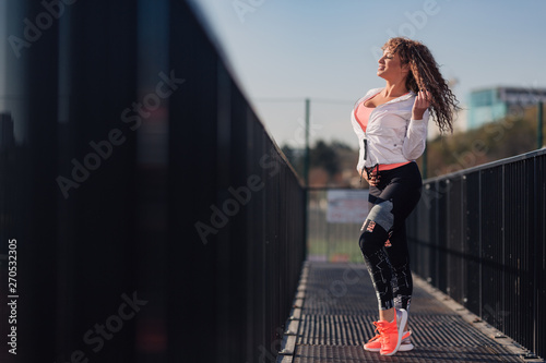 Young attractive woman enjoying outdoor physical exercise in the city