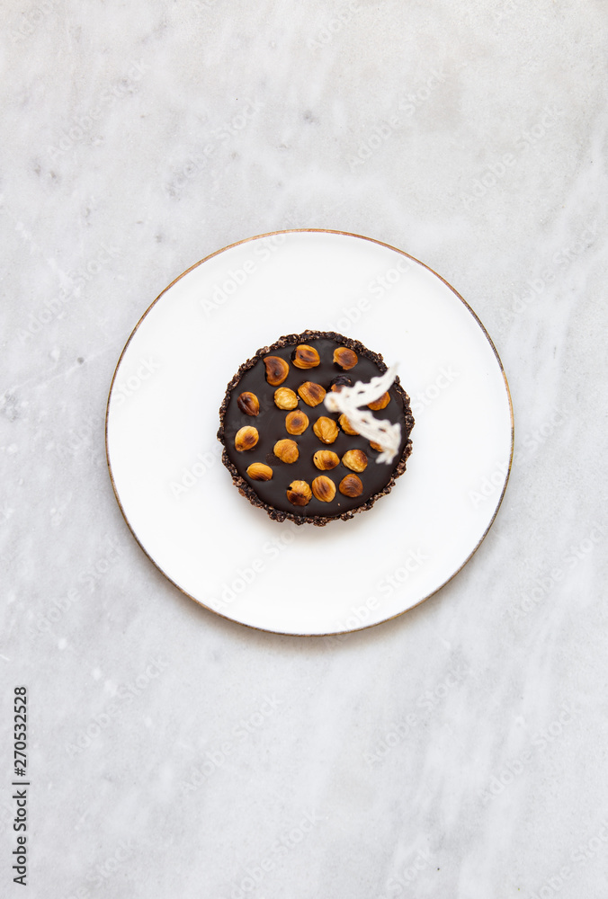 Tartlets with nuts and chocolate on marble background with copy space Tartlets with nuts and chocolate on marble background with copy space