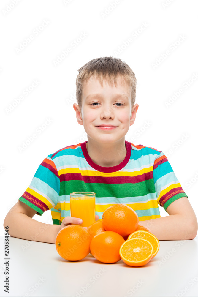 boy with oranges and a glass of fresh orange juice at the table on a white background boy with oranges and a glass of fresh orange juice at the table on a white background