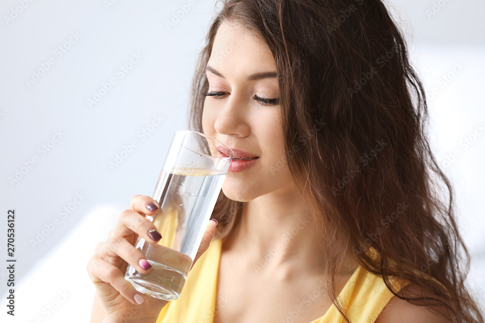 Beautiful young woman drinking water at home Beautiful young woman drinking water at home