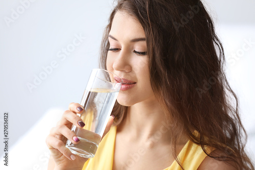 Beautiful young woman drink...