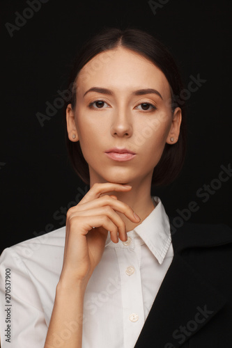 Portrait of a beautiful pacified woman in a white shirt and black jacket. Studio photo session