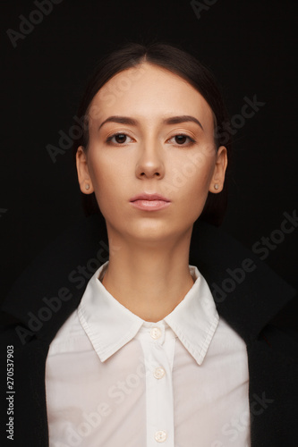 Portrait of a beautiful pacified woman in a white shirt and black jacket. Studio photo session