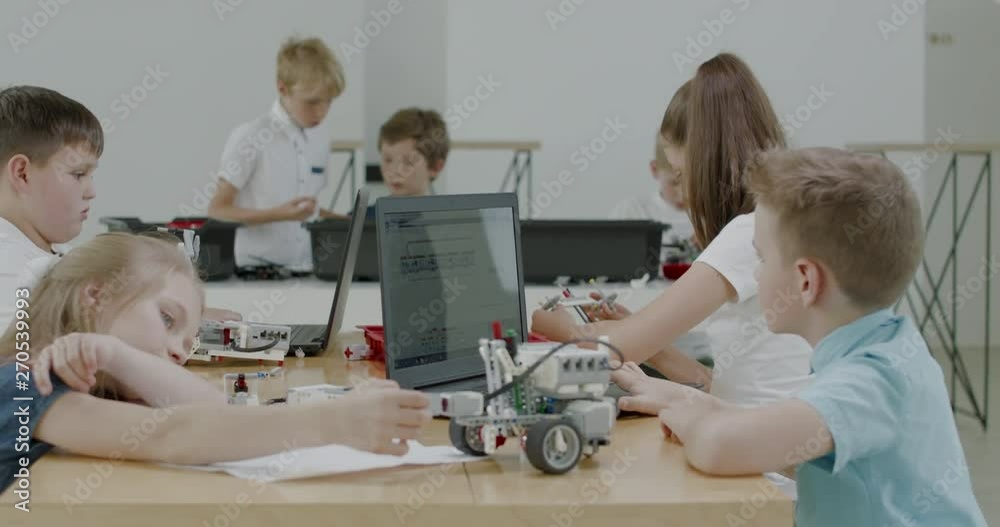 Curious kids working on a functional programable robot during robotics class at school. 4K UHD 60 FPS SLOW MOTION