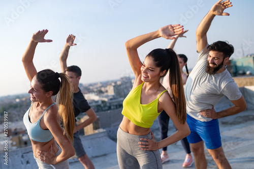 Fitness, sport, friendship and healthy lifestyle concept . Group of happy people exercising