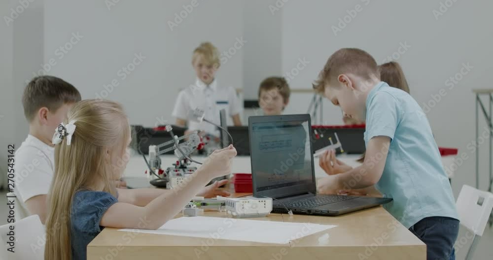 Curious kids working on a functional programable robot during robotics class at school. 4K UHD 60 FPS SLOW MOTION