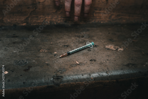 Heroin syringe on rough concrete, dirty background