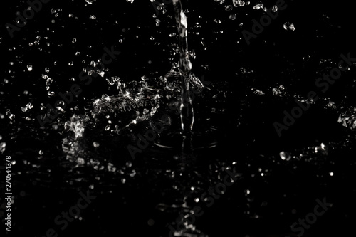 Splashes of water drops on a black background close-up
