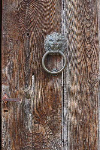 Fototapeta Naklejka Na Ścianę i Meble -  Wooden door with antique door knocker in the shape of a lion's head