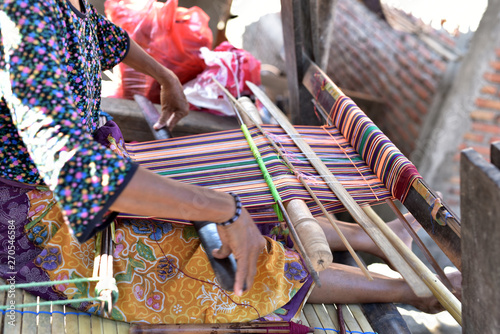 Indonesian woman in a shop producing Songket Lombok in the village Sukarara which is located in the south of the Lombok island, Indonesia