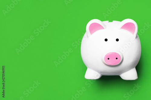 White piggy bank isolated on green. Money saving background.
