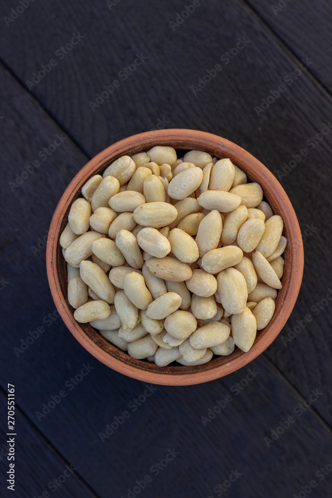 peanuts in ceramic bowl on oak table peanuts in ceramic bowl on oak table