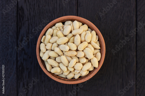 peanuts in ceramic bowl on oak table