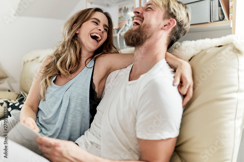 husband and wife laughing  and relaxing on the couch