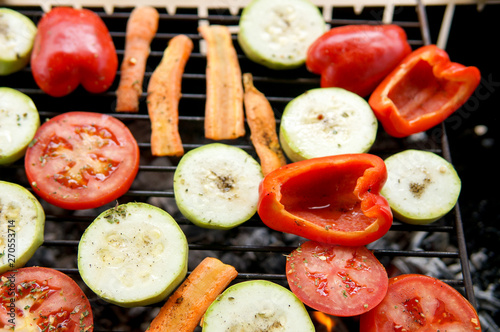 Healthy food preparing outdoors on summer or spring picnic. Grilled vegetables on grill on coals. Barbecue picnic on a meadow