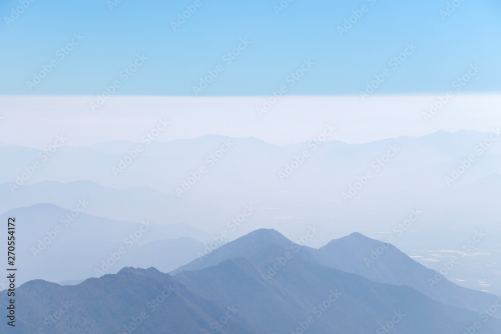 Obraz premium Abstract cascade mountain chains silhouette landscape nackground in a light blue mist sky in morning Andes