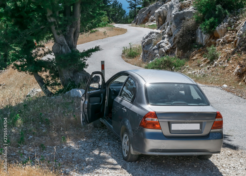 A car with an open door on the mountain road on a summer sunny day. Travel concept A car with an open door on the mountain road on a summer sunny day. Travel concept