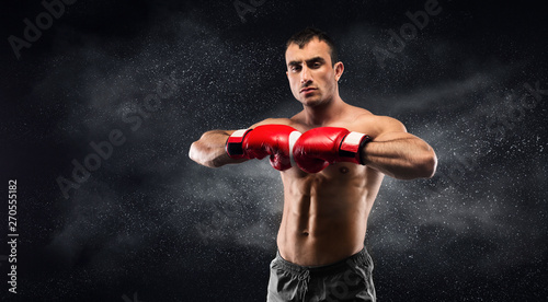 Concentrated boxer preparing for training and posing on camera © Prostock-studio