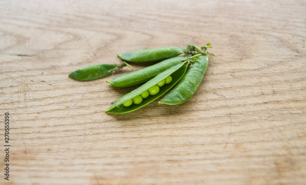 on wooden board lies green peas on wooden board lies green peas