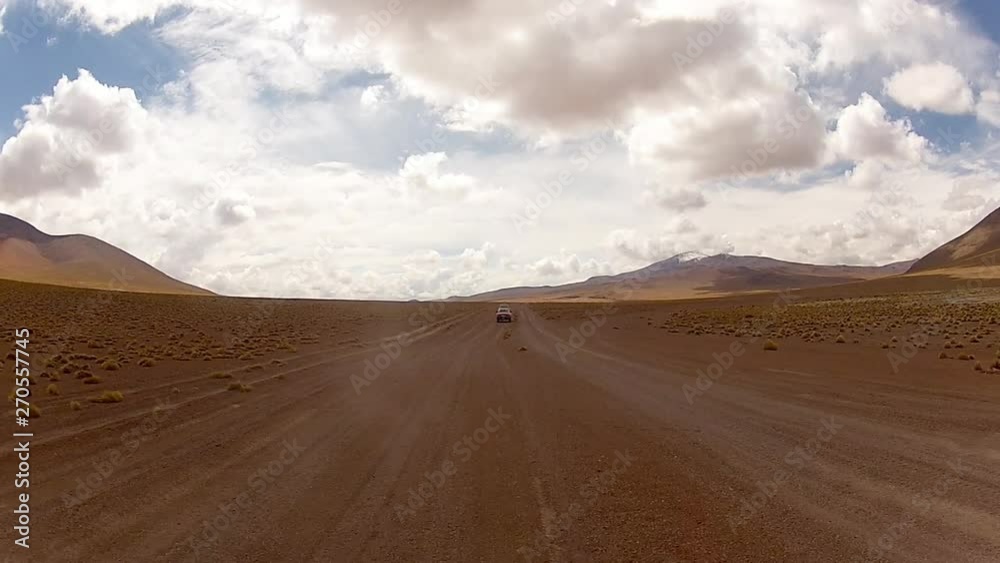 rear view shot of vehicle travelling through desolate landscape, with dust trailing behind rear view shot of vehicle travelling through desolate landscape, with dust trailing behind