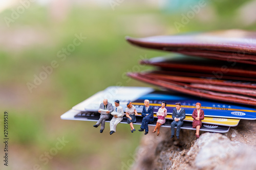 Miniature people   business people sitting on Credit card   Business and Finance concepts
