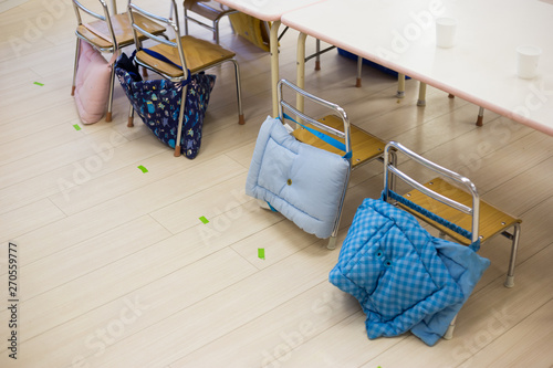 Pillows linked to the chair on a kindergarten in Japan. These pillows will be used in case of an earthquake or any emergency, as helmet for the kids. This is common in Japan.