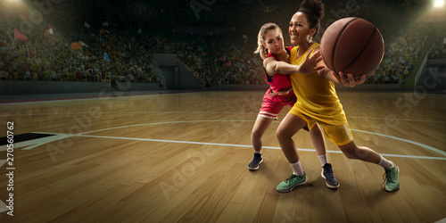 Female basketball players fight for the ball. Basketball players on big professional arena during the game