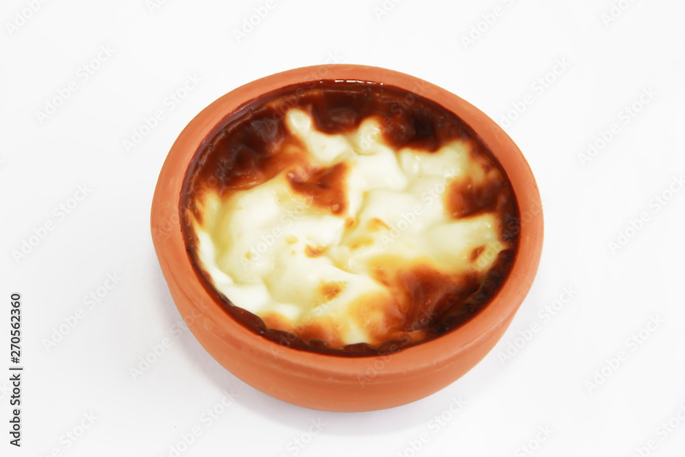 Turkish traditional sweet supangle dish in a clay plate on a white background Turkish traditional sweet supangle dish in a clay plate on a white background