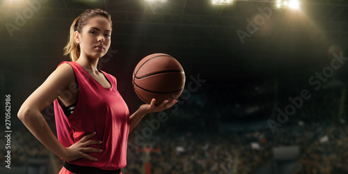 Female basketball player with ball on big professional arena  photo
