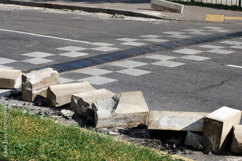 Road works,pieces of concrete uprooted curb blocks on roadway, repairing sidewalk, speed bump on asphalt road © Enso