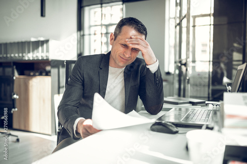 Fototapet Businessman having too many complications working on report