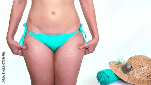 Caucasian woman in bikini squeezing the skin for cellulite and stubborn fat on buttock. Beach body ready series, slimming for Summer, losing weight before holidays, weight loss goals in summertime