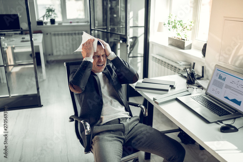 Businessman feeling bad after unsuccessful financial report