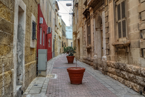 Fototapeta Naklejka Na Ścianę i Meble -  The narrow street in old town of Mosta decorated with flowers
