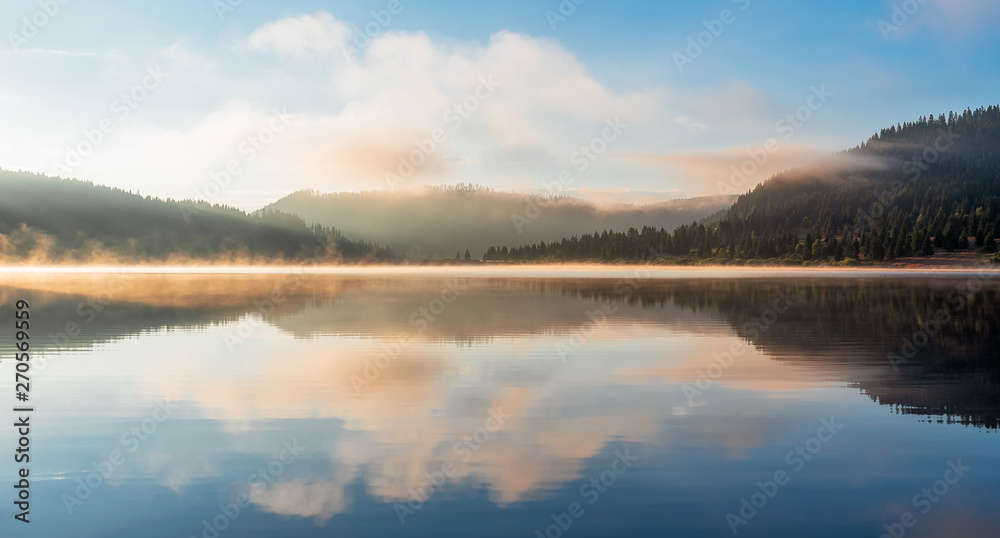 Mountain lake with fog and colorful sky, springtime 