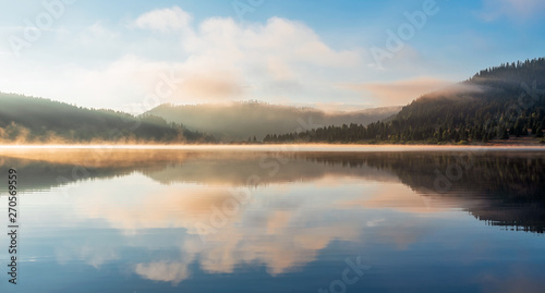 Mountain lake with fog and colorful sky  springtime 